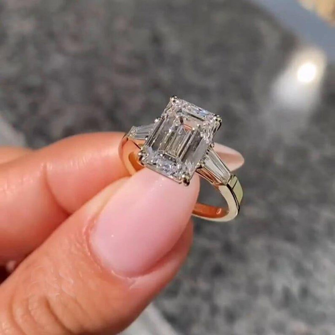 Emerald cut lab grown diamond three stone ring with tapered baguette sides