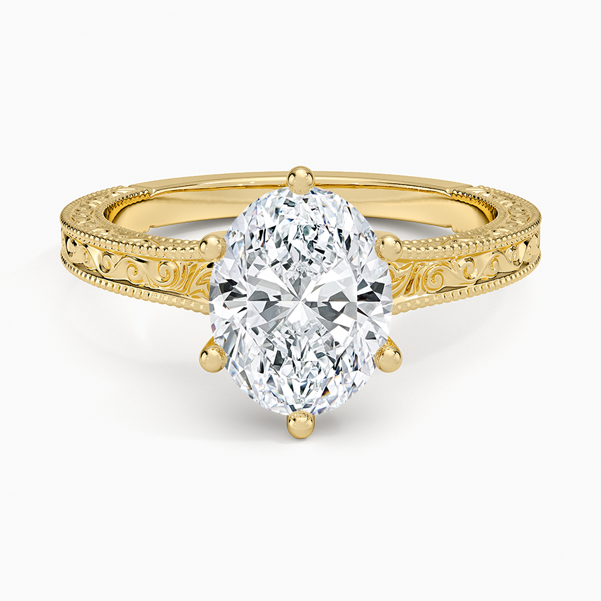 Oval cut lab grown diamond ring on a filigree engraved yellow gold band, top view