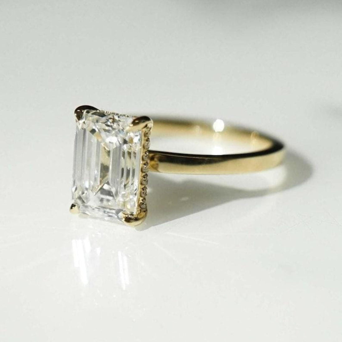 Emerald cut lab grown diamond engagement ring with hidden halo