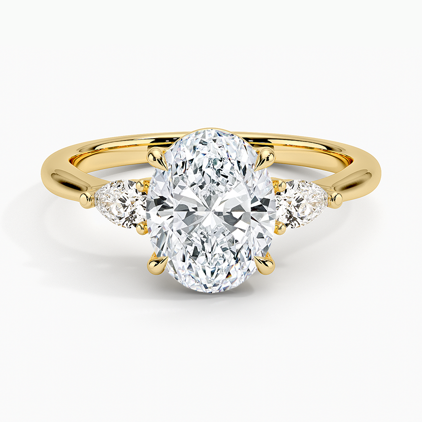 Oval cut lab grown diamond three stone ring with pear side stones in yellow gold, top view