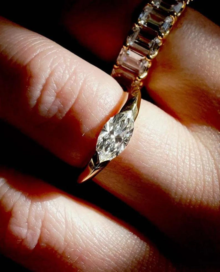 East-west marquise moissanite solitaire ring in yellow gold, on hand