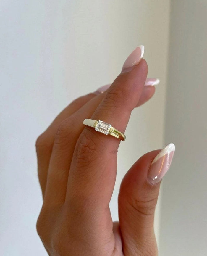 Emerald cut lab grown diamond set east west into a widening shank
