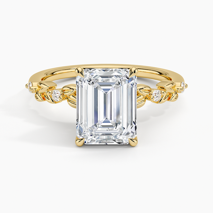 Emerald cut lab grown diamond ring in yellow gold with carved metal leaves and diamond buds along the band, top view