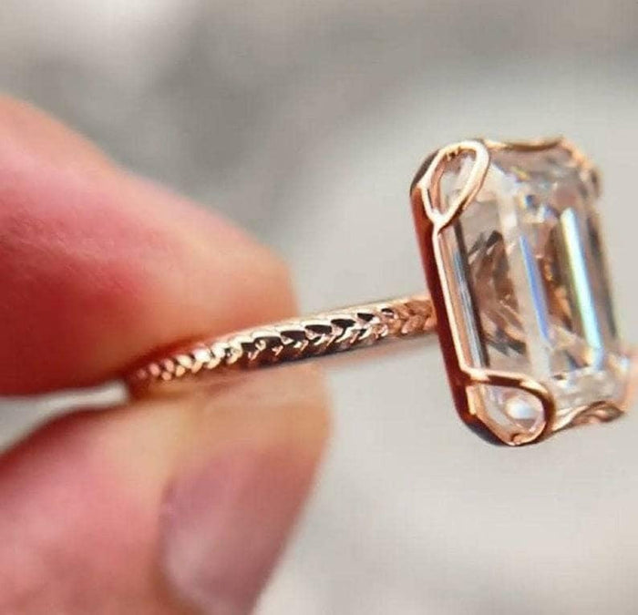 Rose gold emerald cut lab grown diamond bezel ring angled view
