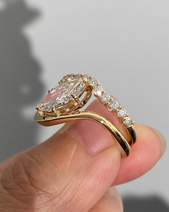 Bezel set marquise diamond engagement ring worn with the matching pave eternity wedding band