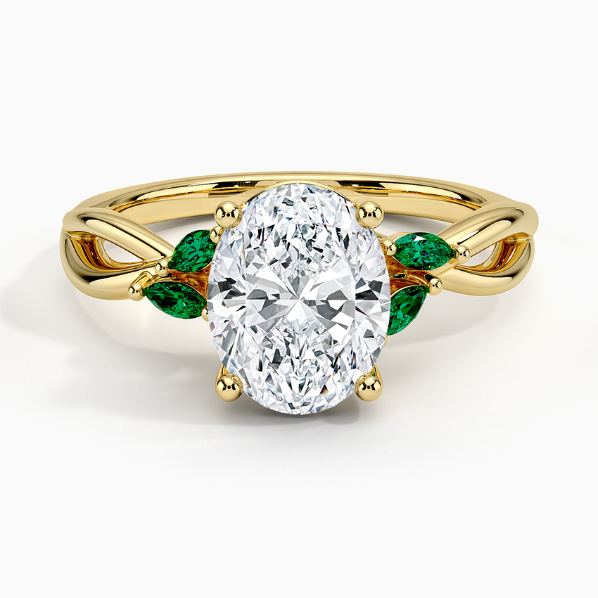 Oval cut lab grown diamond ring with marquise lab emerald leaves on a looping vine in yellow gold, top view