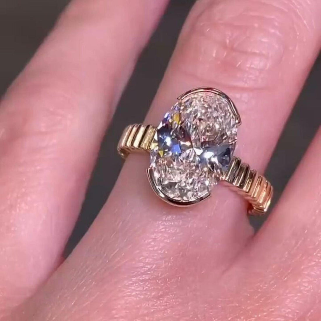 Elongated oval cut lab grown diamond half bezel engagement ring