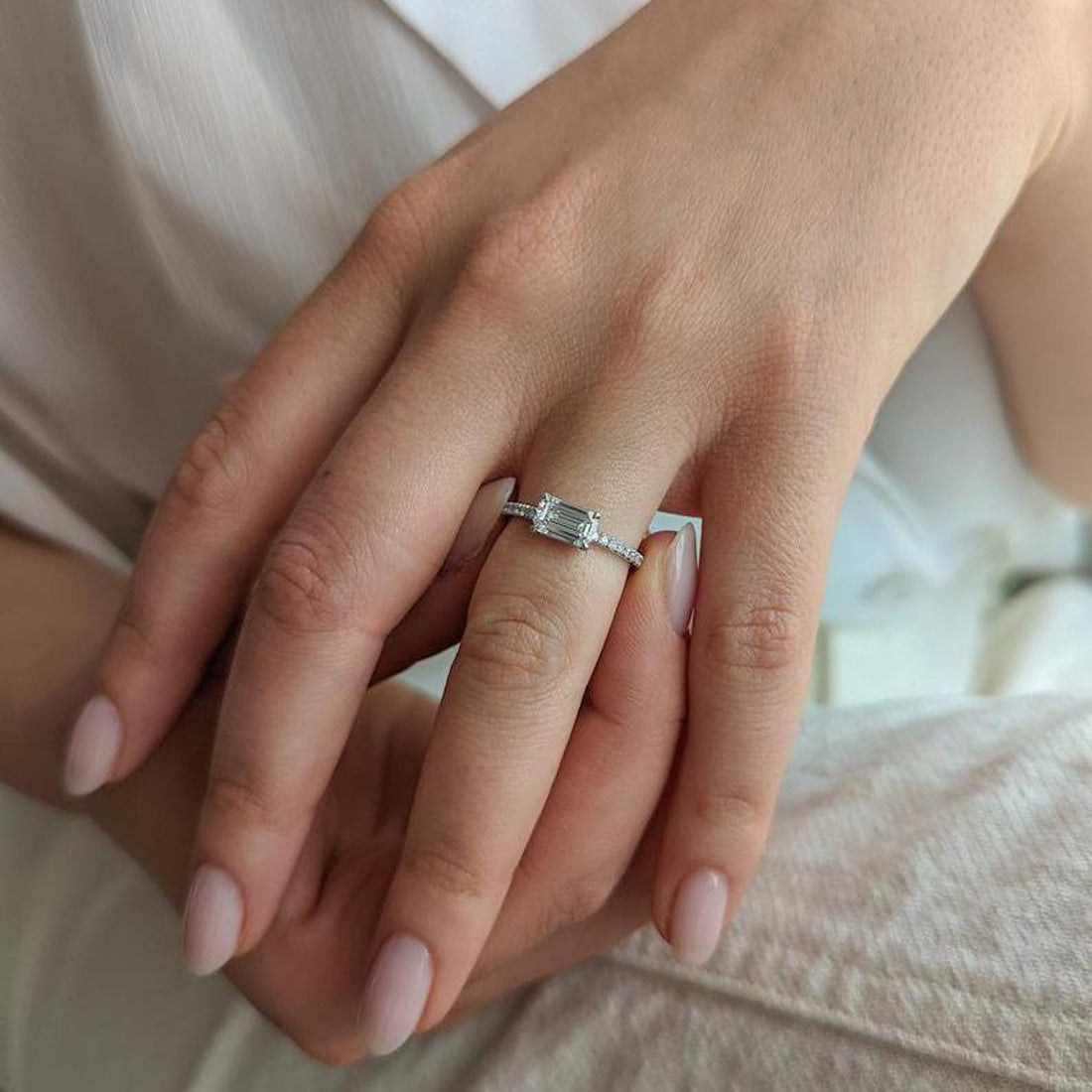 East west emerald cut lab grown diamond ring with pave band