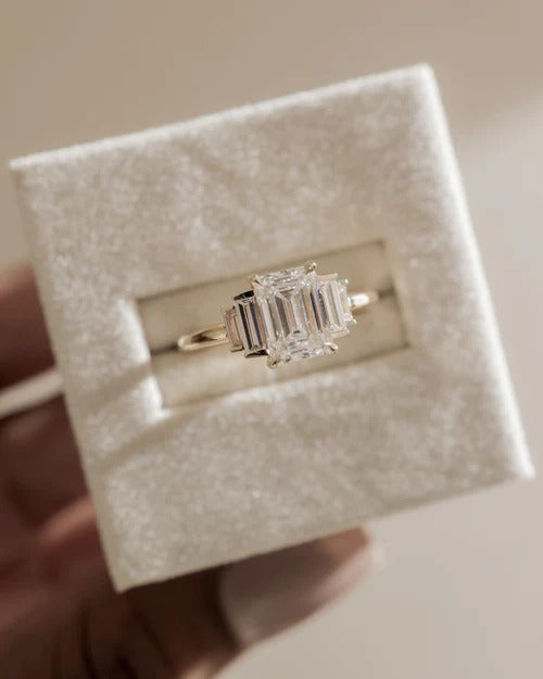 Emerald cut diamond trilogy ring with baguette side stones