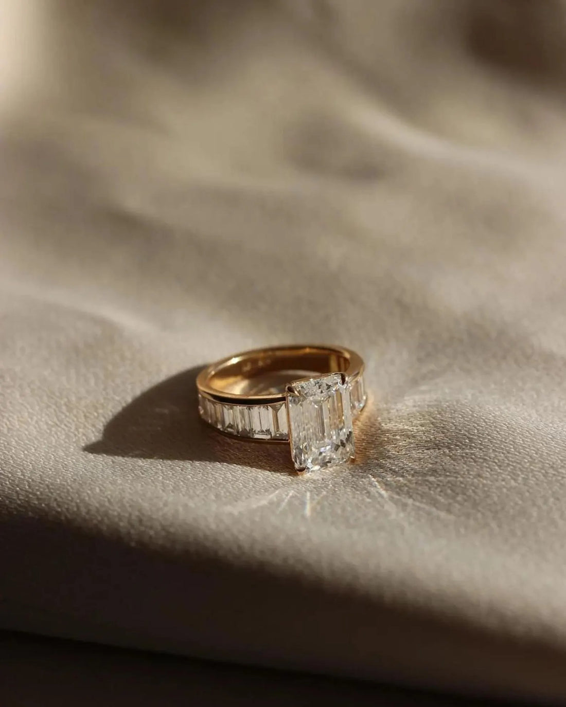 Emerald cut lab grown diamond engagement ring with channel set baguette shoulders in yellow gold