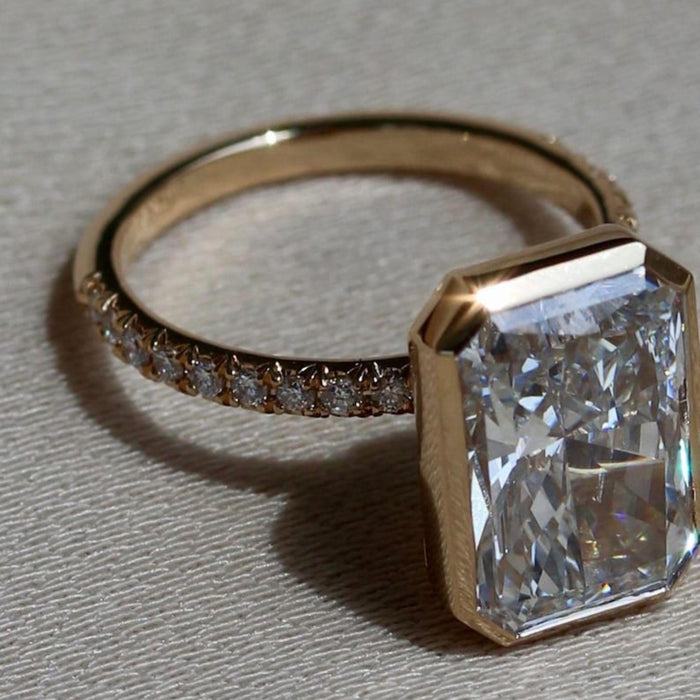 Radiant cut lab grown diamond bezel set engagement ring with pave band