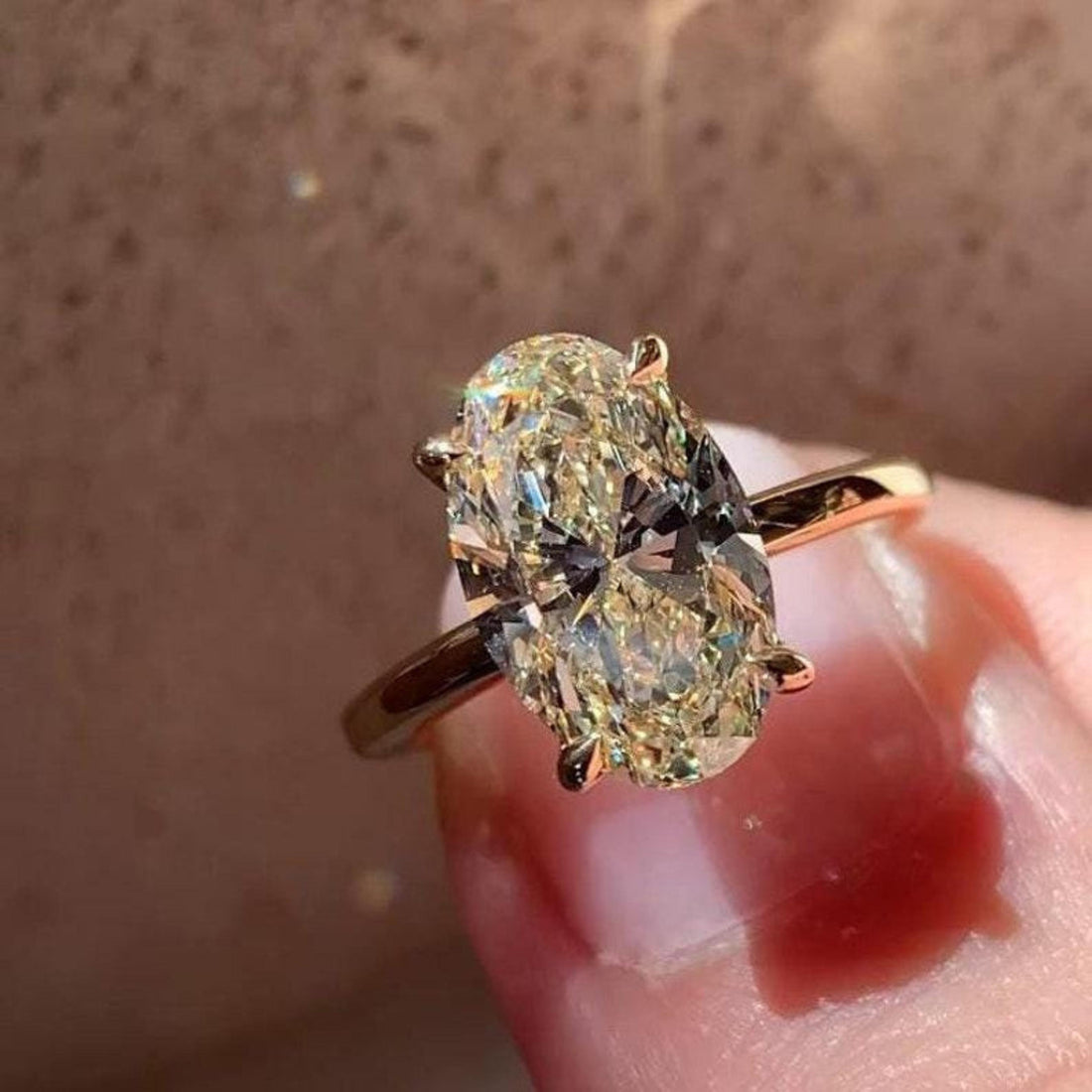 Oval cut lab grown diamond engagement ring with hidden leaf detail beneath the basket
