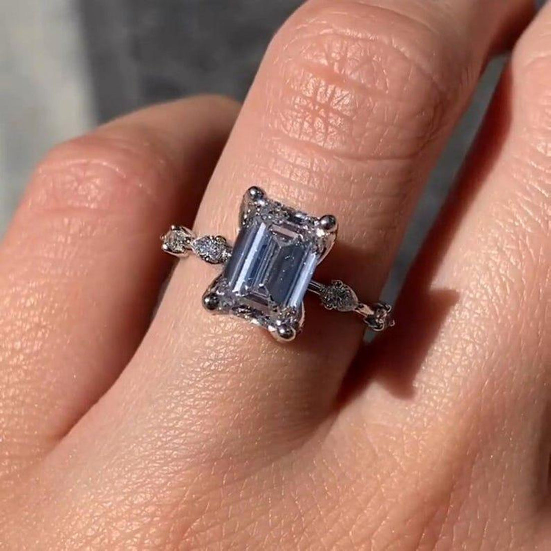 Emerald cut lab grown diamond ring with distance pave band