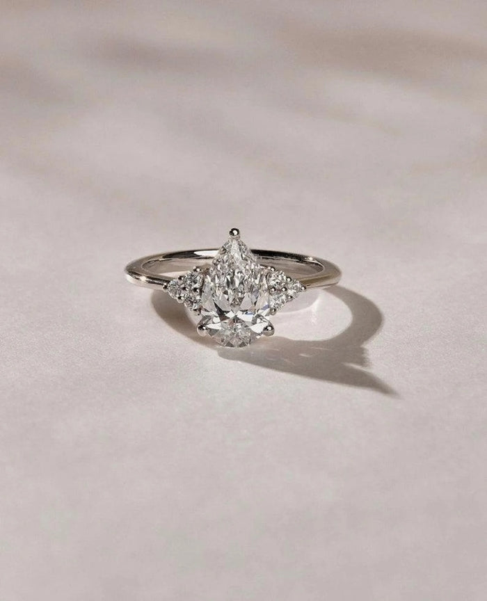 Three stone pear cut lab grown diamond engagement ring with trillion side stones in white gold