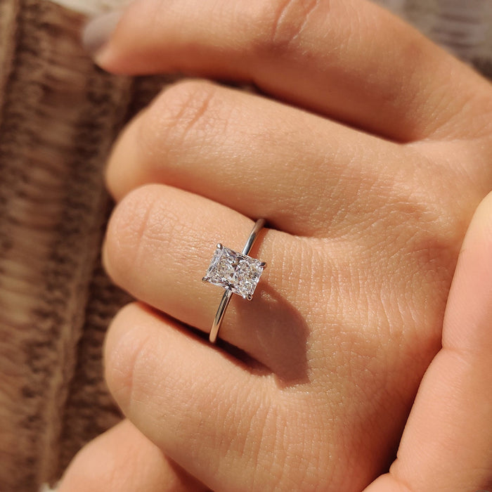 Radiant diamond held in four claws on a plain band
