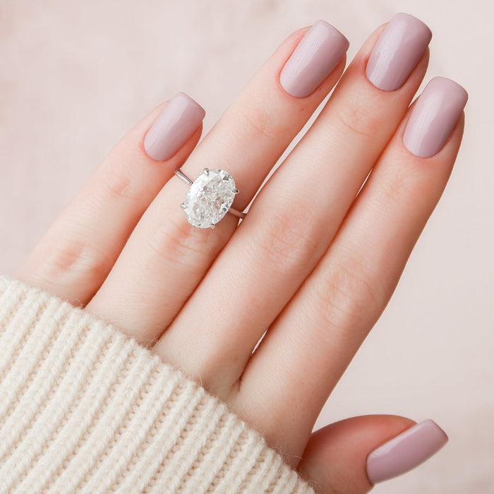 Oval lab grown diamond engagement ring worn on the finger