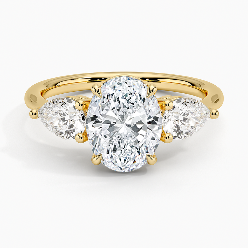Oval cut lab grown diamond three stone ring with large pear sides in yellow gold, top view