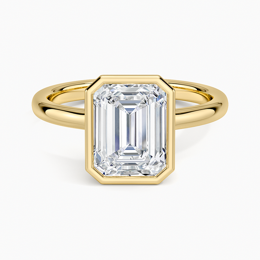 Emerald cut lab grown diamond ring in yellow gold in a solid bezel on a fine round band, top view