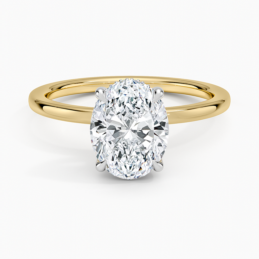 Oval cut lab grown diamond ring with a white gold head on a yellow gold band, top view