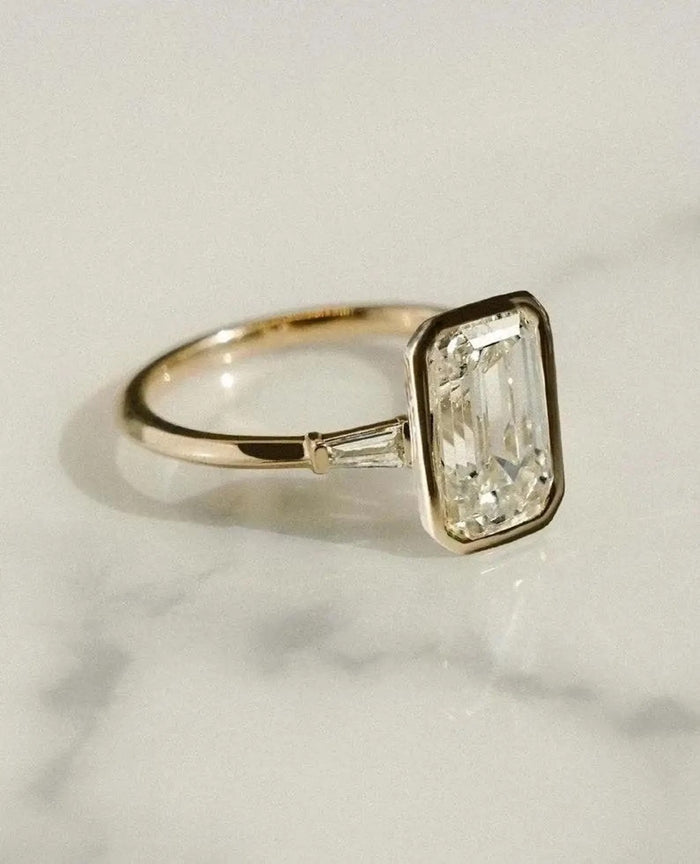 Emerald cut lab grown diamond in a full bezel with baguettes set into the band