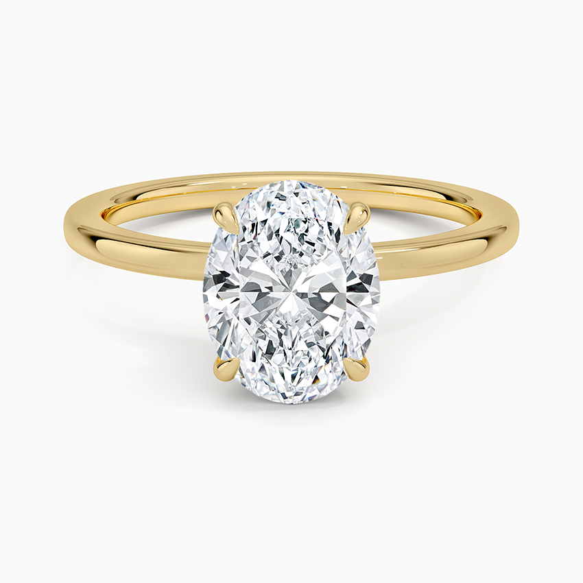 Oval cut lab grown diamond ring with a secret halo on a fine yellow gold band, top view