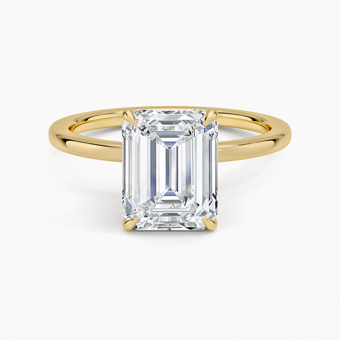 Emerald cut lab grown diamond solitaire ring in yellow gold with a plain band, top view