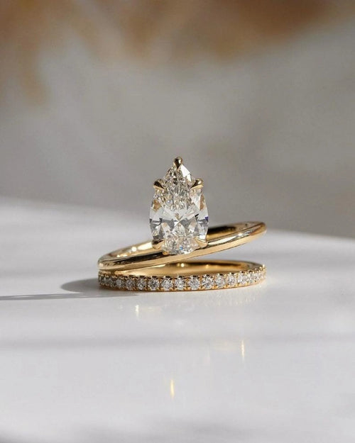 Pear cut lab grown diamond bridal ring set with pave wedding band in yellow gold
