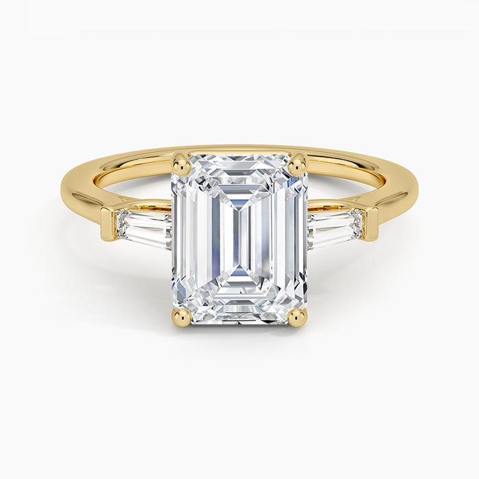 Emerald cut lab grown diamond ring in yellow gold with a tapered baguette diamond on each side, top view