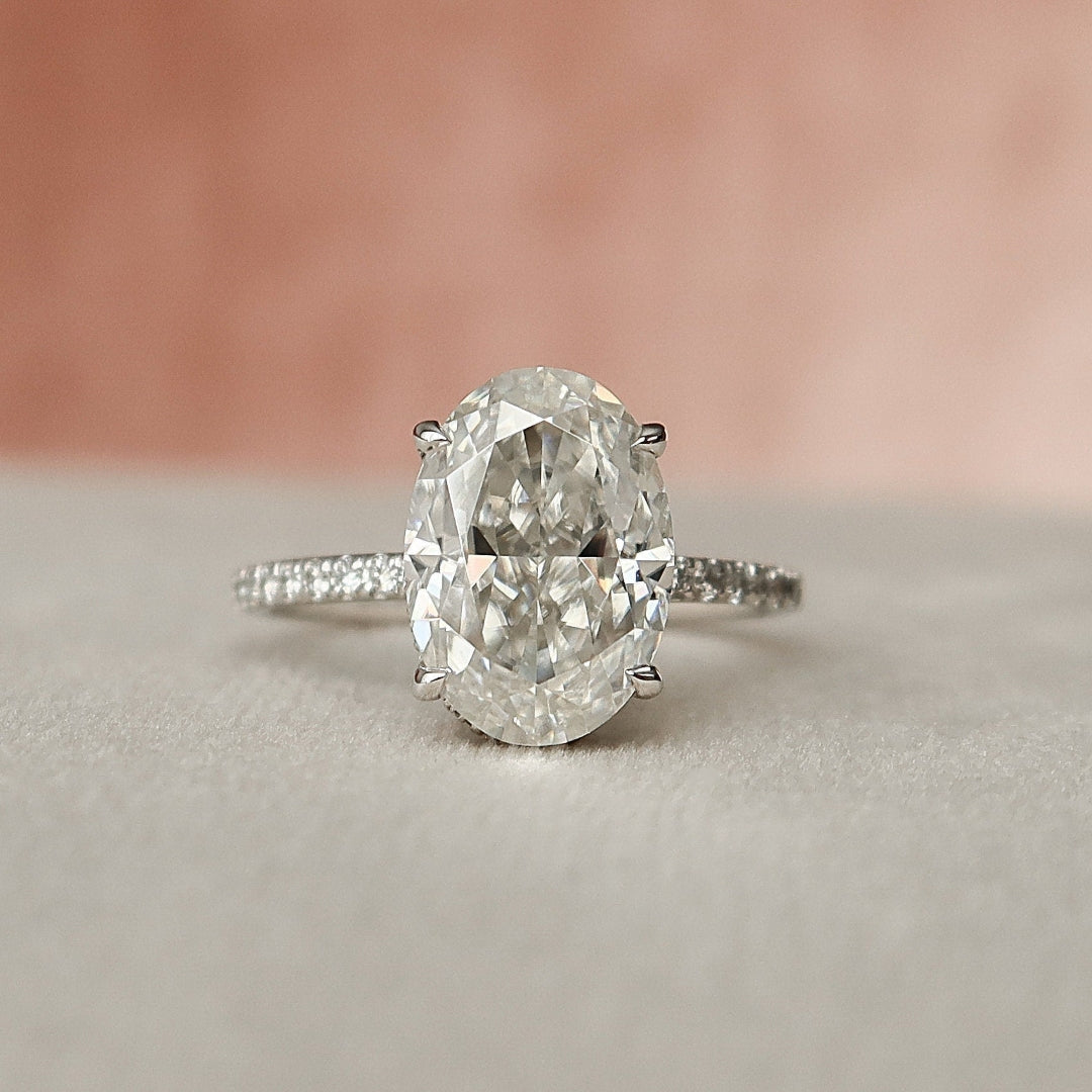 Oval cut lab grown diamond ring with hidden halo and pave shoulders in white gold