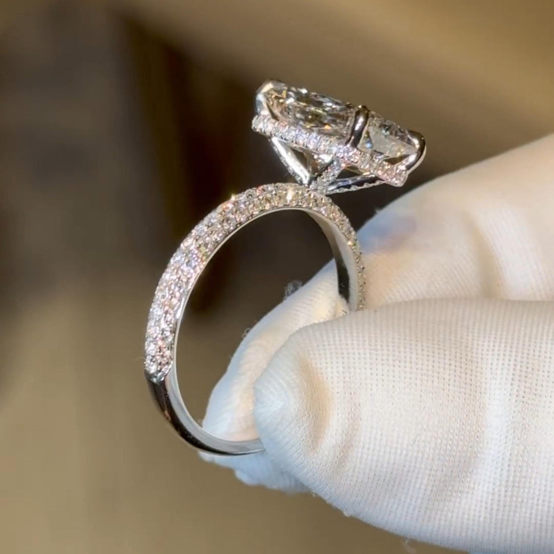 Radiant cut lab grown diamond engagement ring with hidden halo on a triple row pave band