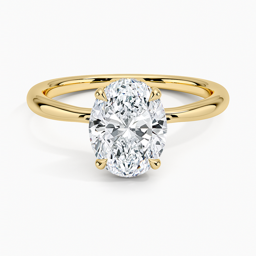 Oval cut lab grown diamond ring with hidden halo on a plain yellow gold band, top view
