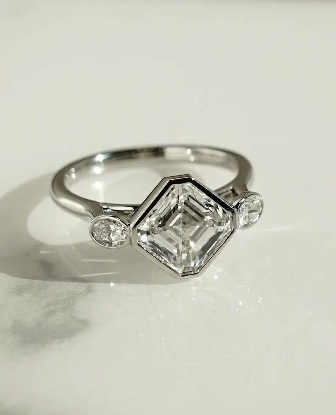 Bezel set Asscher cut lab grown diamond three stone engagement ring in white gold