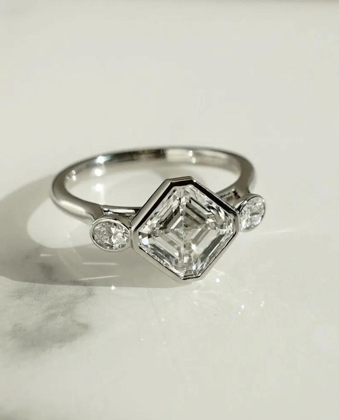 Bezel set Asscher cut lab grown diamond three stone engagement ring in white gold