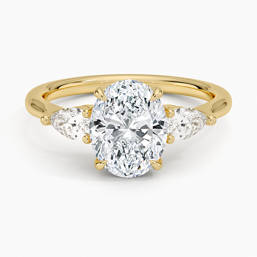 Oval cut lab grown diamond three stone ring with large pear side stones in yellow gold, top view