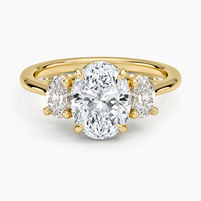 Oval cut lab grown diamond trilogy ring with large oval side stones in yellow gold, top view