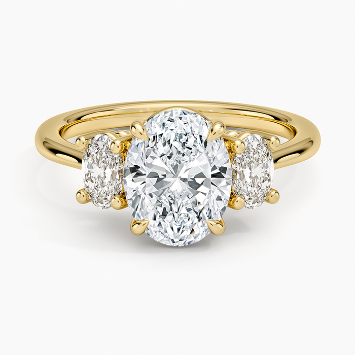 Oval cut lab grown diamond trilogy ring with large oval side stones in yellow gold, top view