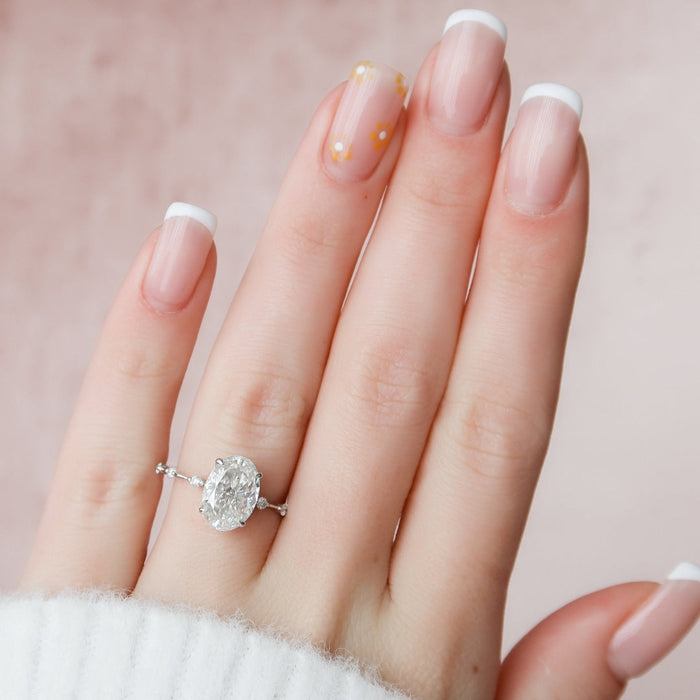 Oval lab grown diamond engagement ring with spaced diamond stations