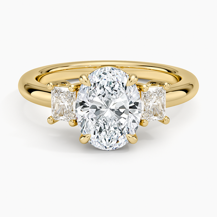Oval cut lab grown diamond three stone ring with tall radiant cut side stones in yellow gold, top view
