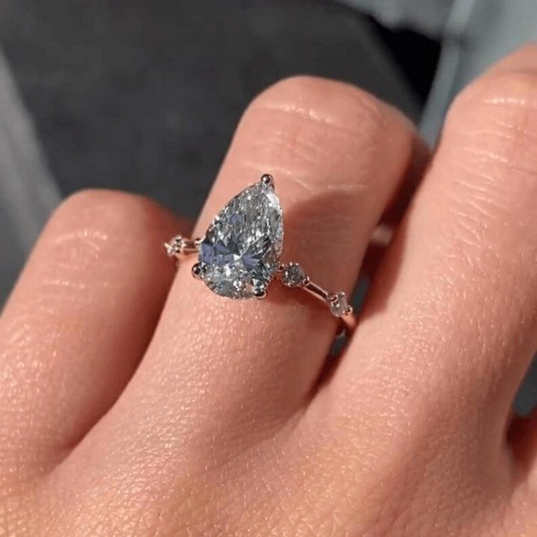 Pear cut lab grown diamond engagement ring with distance set pave band