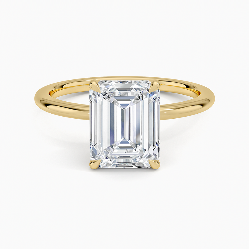 Emerald cut lab grown diamond solitaire ring in yellow gold on a slim polished band, top view