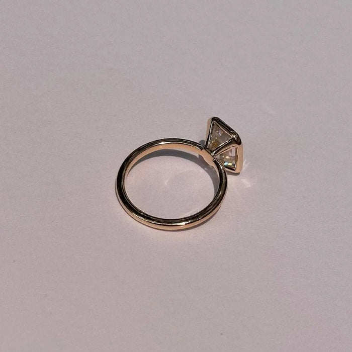 Emerald cut lab grown diamond in a full bezel, angled view