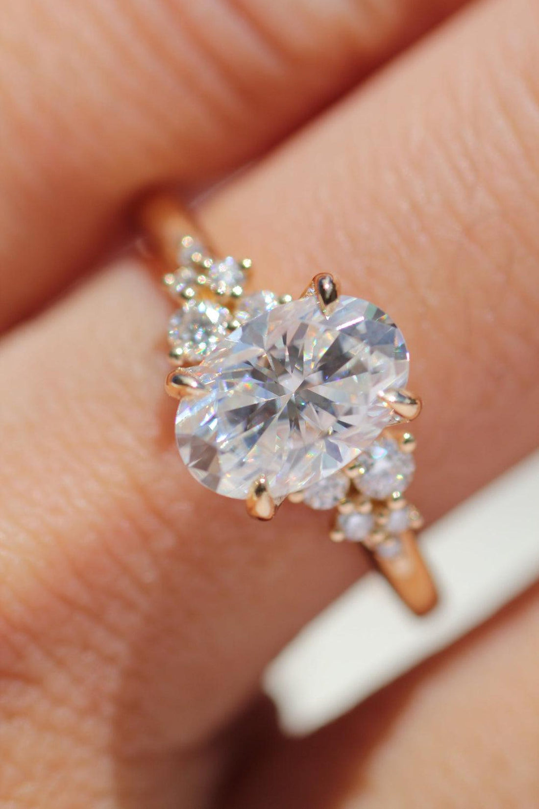 Oval cut lab grown diamond engagement ring with scattered cluster accents in rose gold