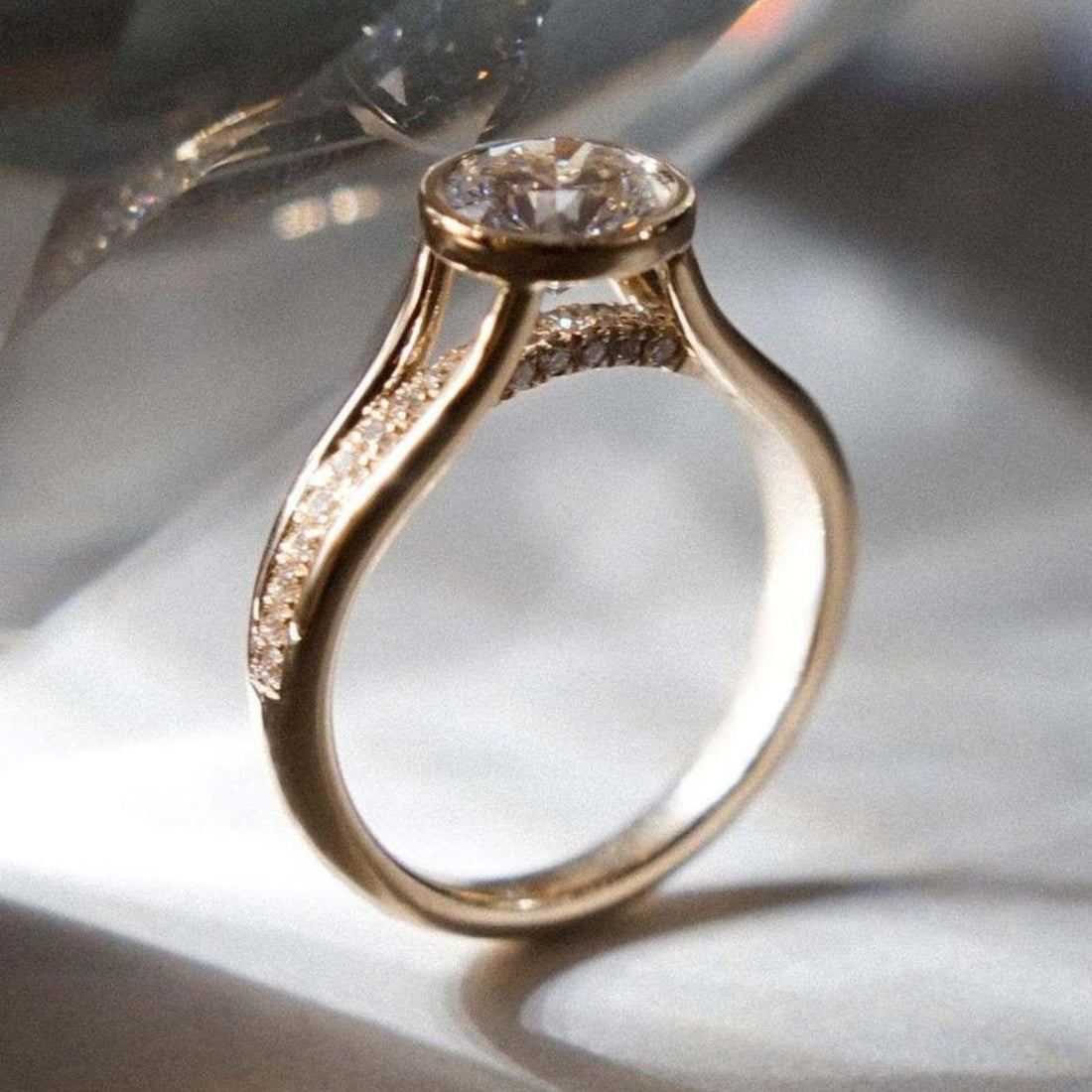 Round cut lab grown diamond bezel set engagement ring with hidden halo and split shank