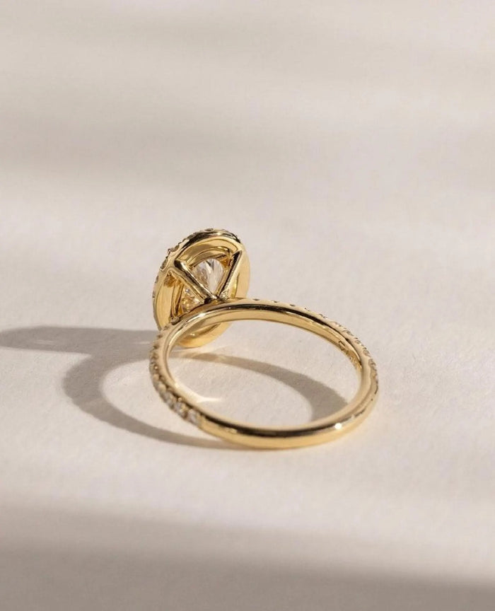 Halo of round accents framing the oval cut lab grown diamond