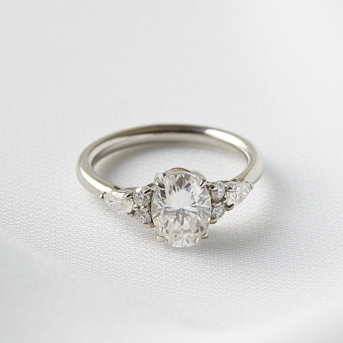 Oval lab grown diamond engagement ring with pear side stones