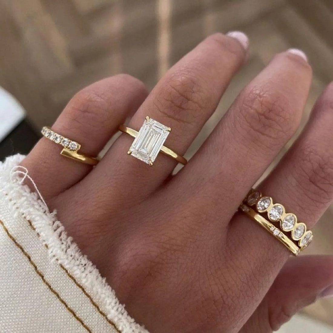 Elongated emerald cut lab grown diamond solitaire engagement ring on a plain yellow gold band