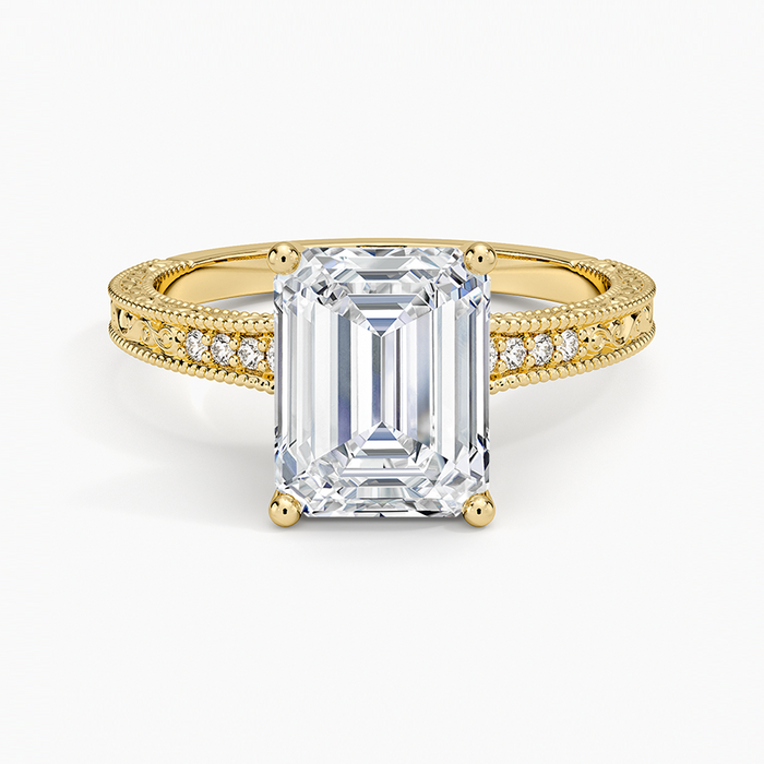 Emerald cut lab grown diamond ring in yellow gold with milgrain edged pave shoulders and engraved sides, top view