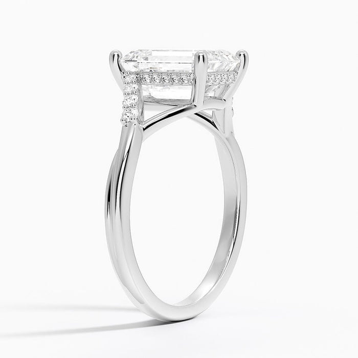 Profile view showing the split shank passing under the emerald cut stone