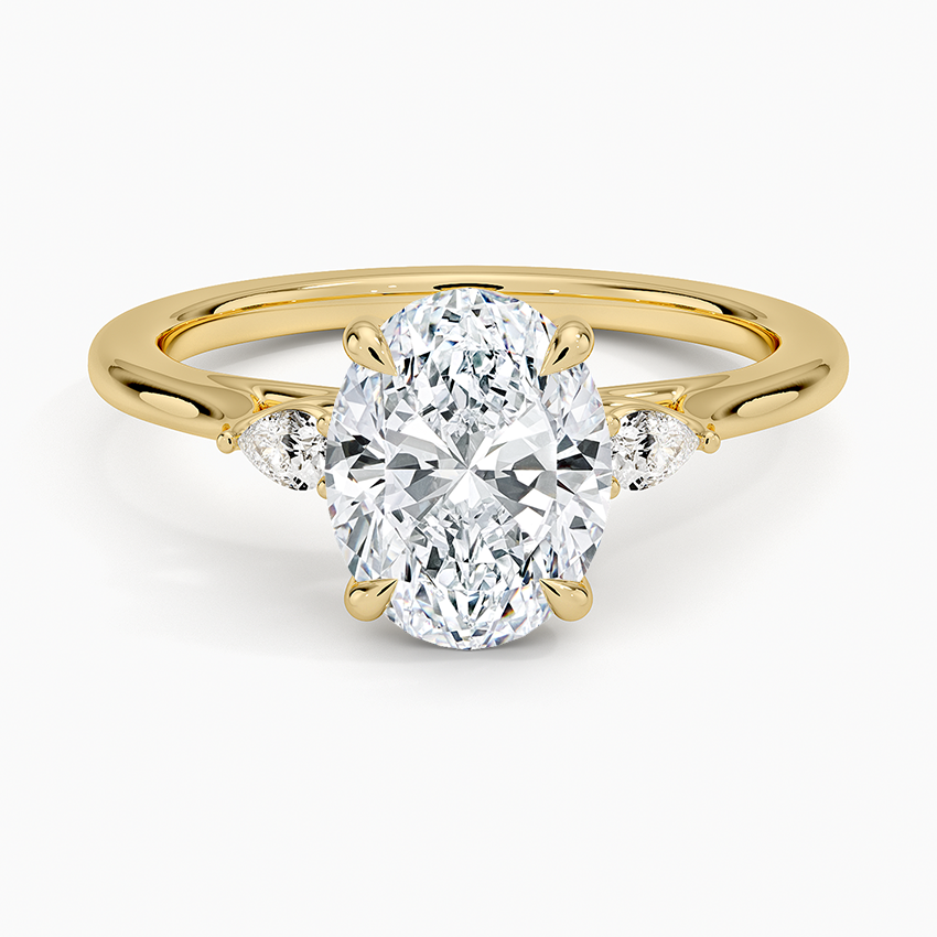 Oval cut lab grown diamond ring with small pear side accents in yellow gold, top view