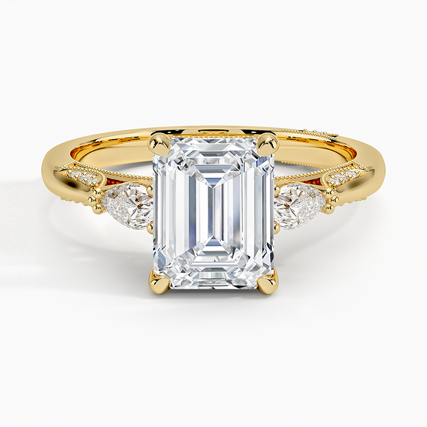 Emerald cut lab grown diamond three stone ring with pear side stones in yellow gold, top view